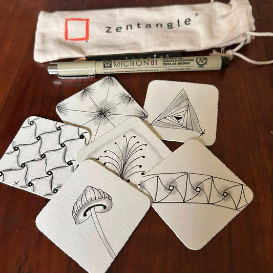 Zentangle cards with a pen and pouch on a wooden surface